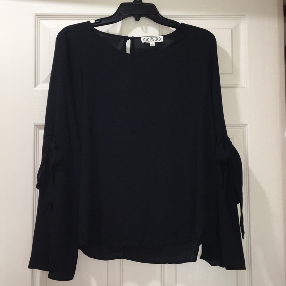 A black blouse with a bow on each sleeve